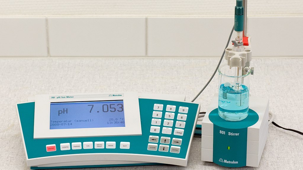Medidor de pH de mesa con el electrodo sumergido en una solución de prueba, mostrando pH 7,053 a 25,0 °C